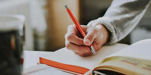 Hand, die schreibt und Buch